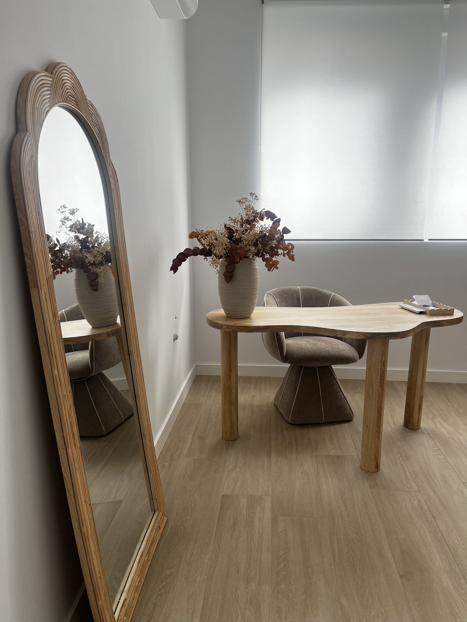 Rincón de espera con espejo y mesa decorativa